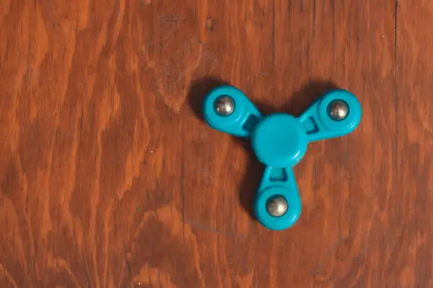 fidget spinner on wooden desk in isolated background to fill