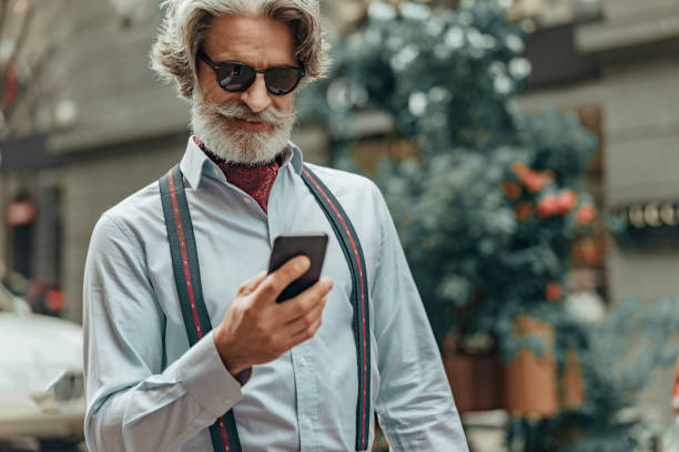 istock Smiling senior man using smartphone on the street 1171393492