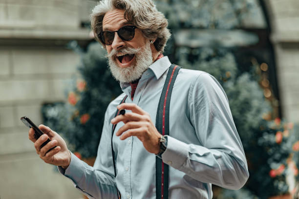 istock Cheerful senior man using cellphone on the street 1171393494