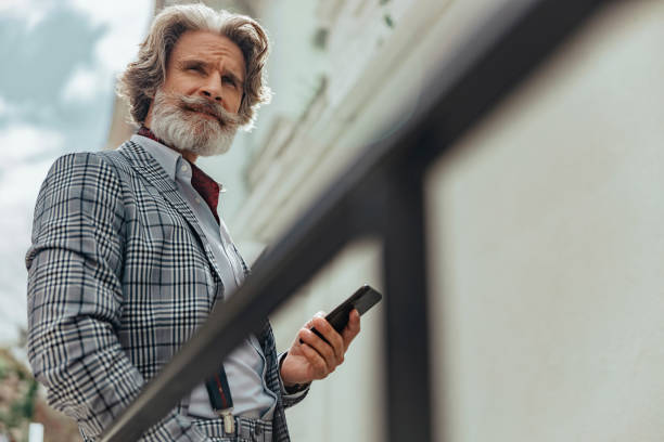istock Good-looking senior man is using cellphone outdoors 1171393650