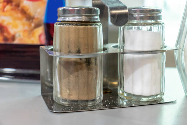 Seasoning spices salt and pepper metal shakers on the table in the restaurant Seasoning spices salt and pepper metal shakers on the table in the restaurant. salt pepper ingredient black peppercorn stock pictures, royalty-free photos & images