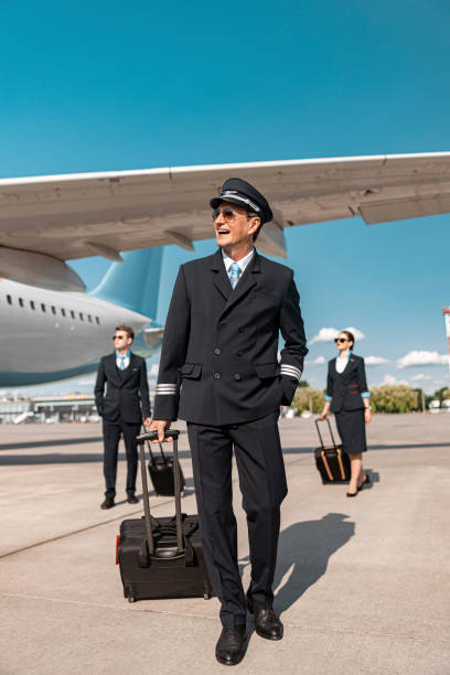 istock Attractive Caucasian pilot with suitcase walking in airport 1171400389