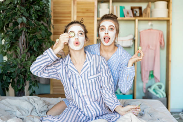 chicas maravillosas con trozos de pepino en los ojos - facial mask spa treatment cucumber human face fotografías e imágenes de stock