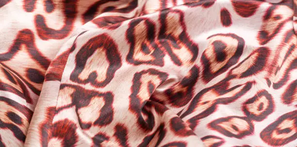 Photo of texture, background, pattern. silk fabric, tiger skin, light and silky soft, this atlas charmeuse is perfect for your projects - especially on bias. Colors include tan, black and brown.