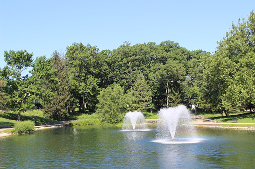 Fountains in Dreamland Lake, Decatur, IL on Sunny Summer Day beneath Blue Sky