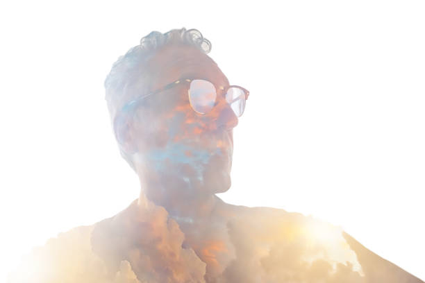 Multiple Exposure of senior man morphing into cloudscape