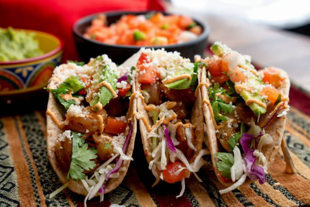 Colorful Street Tacos, Shrimp - Seafood, Fish, Grilled, Ready-To-Eat A beautiful arrangement of shrimp tacos with pico de gallo, avocado, cilantro, chipotle sour cream, and cotija cheese mexican food photos stock pictures, royalty-free photos & images