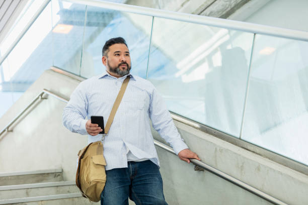 istock Hispanic man walking down stairs outside building 1171426876