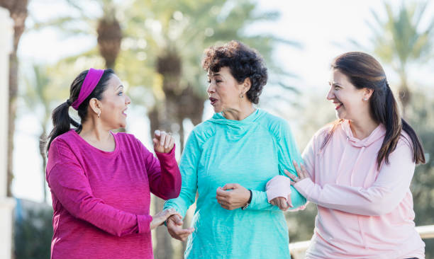 istock Three Hispanic women walking and talking in park 1171429214