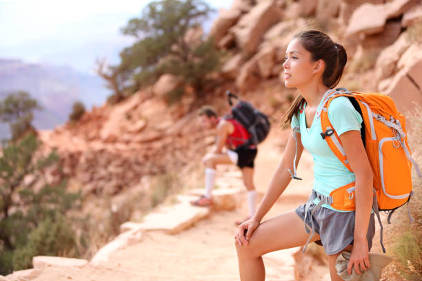 Hiker in Grand Canyon. Hiking woman and man resting tired enjoying hike and view on South Kaibab Trail, south rim of Grand Canyon, Arizona, USA.