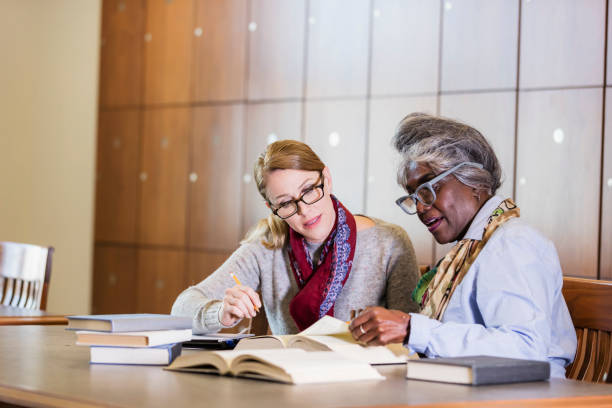 istock Two women doing research in the library together 1171430438