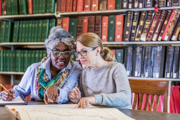 istock Two women doing research in the library together 1171430535