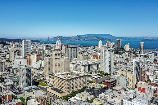 An aerial view of Nob Hill and the Golden Gate Bridge on a clear and sunny day. Famous hotels and buildings are visible.