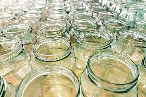 Lots of empty transparent jars in rows background.