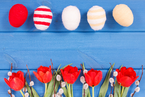 Tulipanes, amentos y huevos envueltos en cuerda de lana como decoración festiva de Pascua, copiar espacio para el texto photo