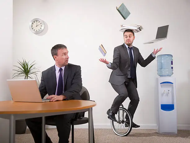 younger office worker shows older colleague how to multi-task