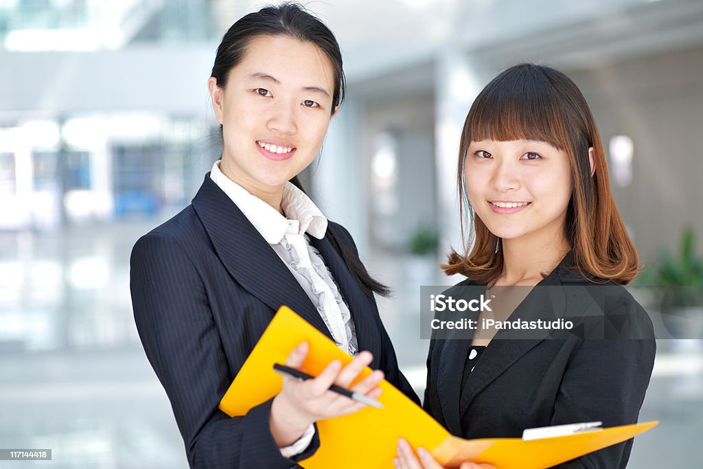 Два молодых деловых, улыбается в камеру - Стоковые фото Азия роялти-фри