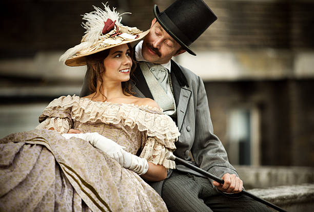 Victorian couple in love having a good time together Victorian couple in love having a good time together, young smiling woman looks happy, men looking at her. period costume stock pictures, royalty-free photos & images