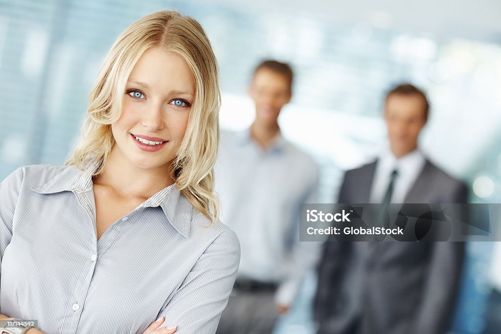 Hermosa mujer executive con colegas en fondo - Foto de stock de 20 a 29 años libre de derechos