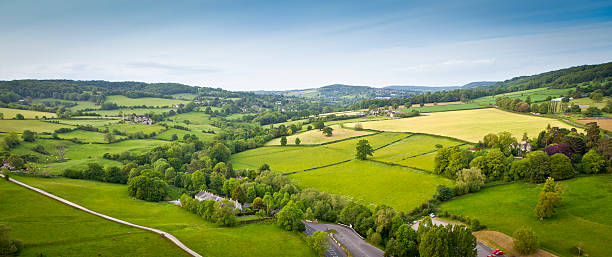 Idyllic rural, aerial view, Cotswolds UK Dramatic aerial view of gently rolling patchwork farmland with pretty wooded boundaries, in the beautiful surroundings of the Cotswolds, England, UK. Stitched panoramic image. patchwork landscape stock pictures, royalty-free photos & images