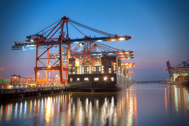 A ship docked at a harbour at night time Harbour at night in Hamburg, Germany. Container terminal with container cargo ships. hamburg germany photos stock pictures, royalty-free photos & images