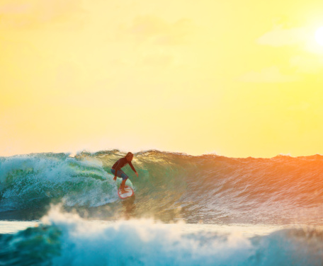 surfer riding perfect wave on sunset, Bali, Indonesia\n\n[url=http://www.istockphoto.com/search/lightbox/8407763 t=_blank][img]http://i203.photobucket.com/albums/aa6/arand-design/banners/Surfing.jpg[/img][/url]