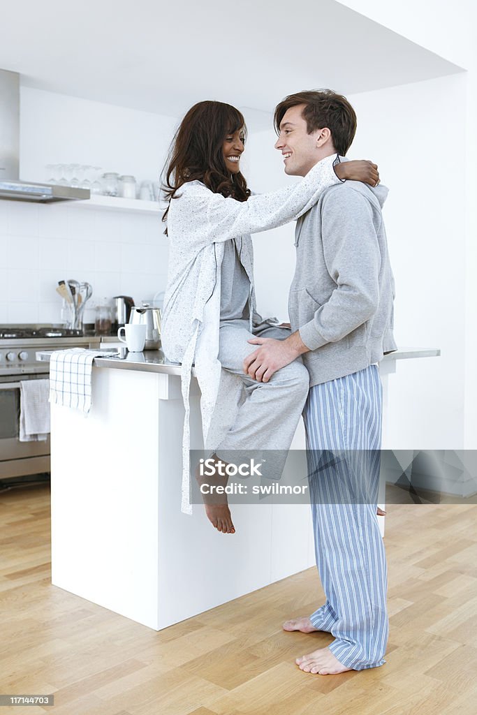 Jovem casal na cozinha vestindo Pijamas - Foto de stock de Abraçar royalty-free