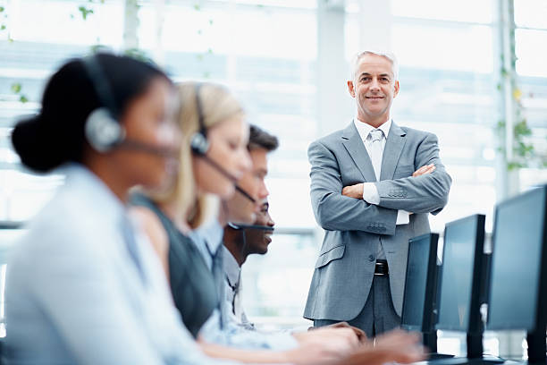 istock Manager standing in call center with team working 117144725