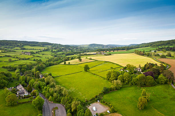 Idyllic rural, aerial view, Cotswolds UK Dramatic aerial view of gently rolling patchwork farmland with pretty wooded boundaries, in the beautiful surroundings of the Cotswolds, England, UK. Stitched panoramic image. patchwork landscape photos stock pictures, royalty-free photos & images