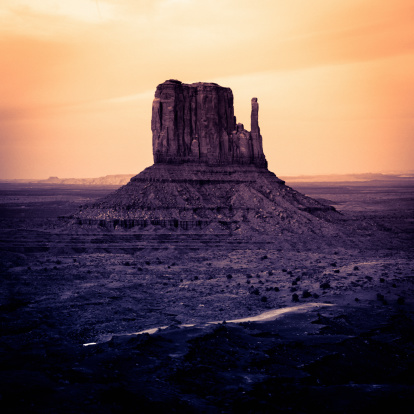 Monument Valley. Classic Wild West landscape. Sunset, toned for the mood. Digital noise added to avoid banding in the sky.