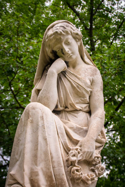 istock A stone lady sitting in a cemetery crying over a grave 1171448819
