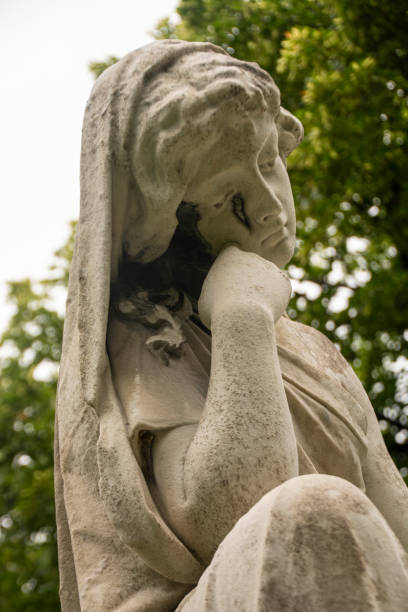 istock A stone lady sitting in a cemetery crying over a grave 1171448837