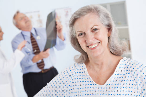 istock Adult Patient in Doctor's Office While Doctors Look at X-Ray 117144896