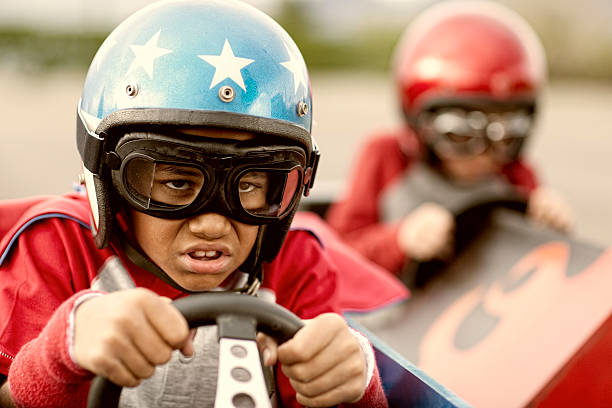 Kid Racer A young African American boy races his soapbox car to eternal glory. soapbox cart stock pictures, royalty-free photos & images