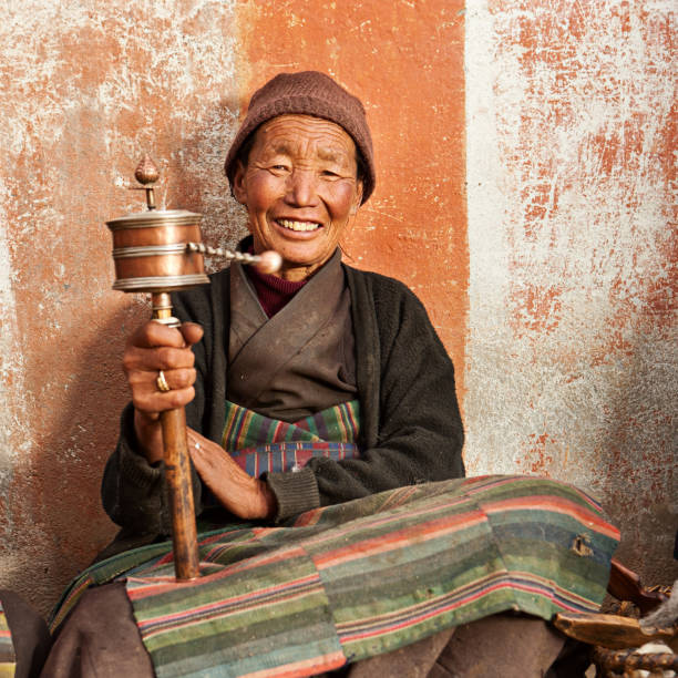 istock Tibetan woman with prayer wheel 117145012