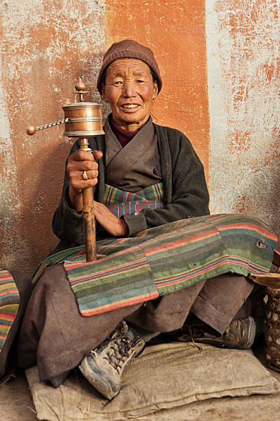istock Tibetan woman with prayer wheel 117145015