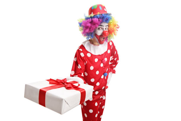 istock Funny clown holding a gift box and making a grimace 1171450223