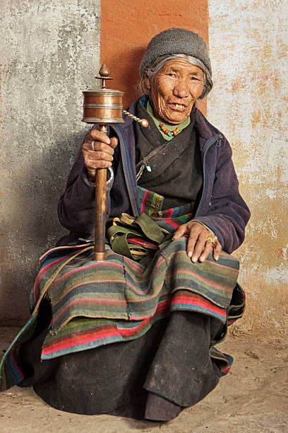 istock Tibetan woman with prayer wheel 117145029