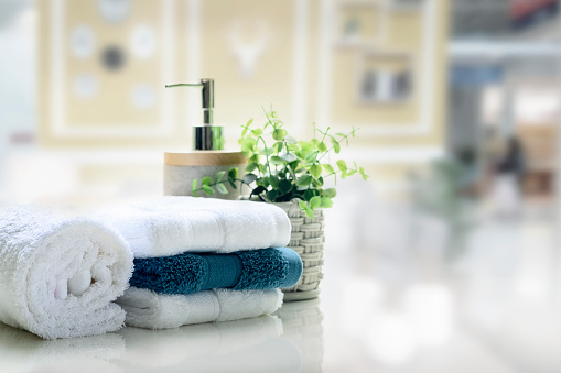 White towels on white top table with copy space on blurred living room background. For product display montage.