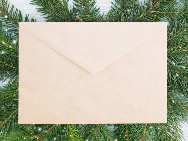 Fir tree branch with envelope, snowflake on white wooden background. Winter holidays concept