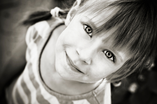 Black and white portrait of a little girl with a big spectacle screams