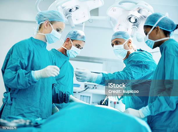 Group Of Surgeons In Operating Room Stock Photo - Download Image Now - Adult, Adults Only, Color Image