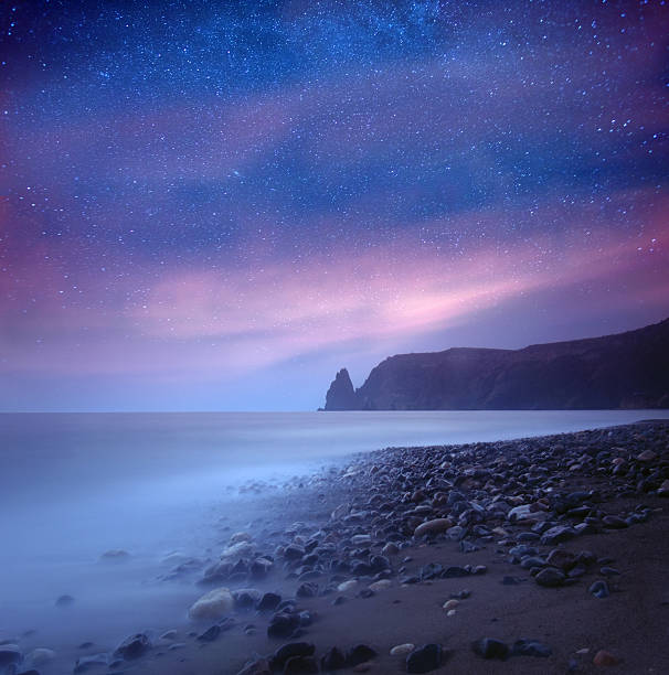 море на вечер под звездами млечный путь - moody sky outdoors digital composite sunset стоковые фото и изображения
