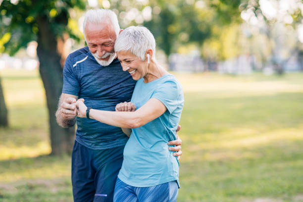 Senior couple jogging Senior smiling couple in sports wear jogging together and checking the time at smartwatch. pedometer photos stock pictures, royalty-free photos & images