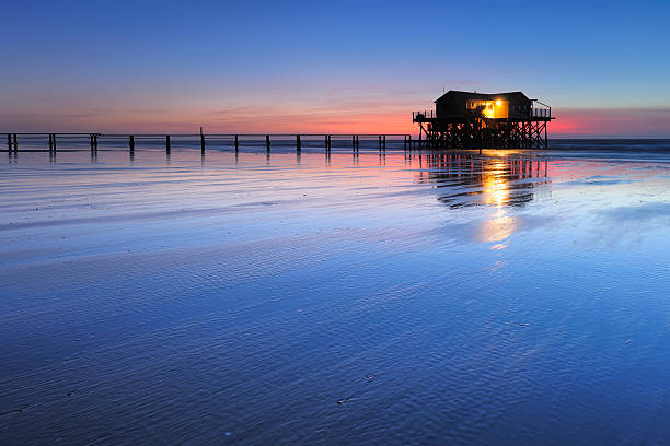 Tranquil Coastal Sunset, Jetty and Stilt House on Sand Beach