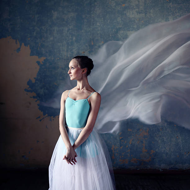 Ballerina sitting on dark stage