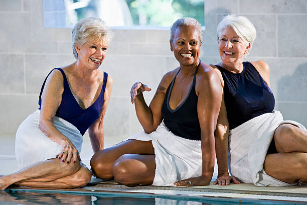 multiraciale femmes âgées assis au bord de la piscine - sc0450 photos et images de collection