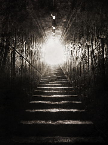 Looking up the ascending stairs of an egyptian tomb, into the light.