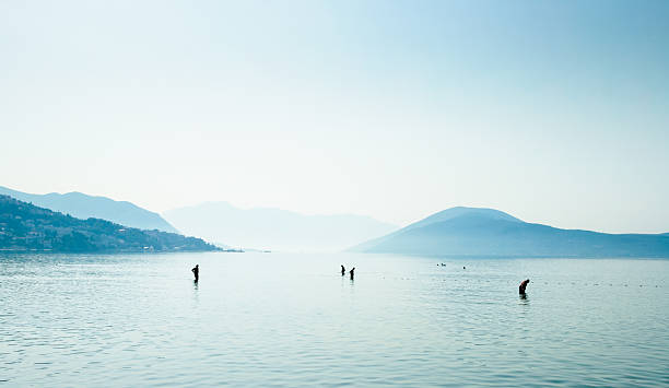 People walking in shallow water on the coast of Montenegro