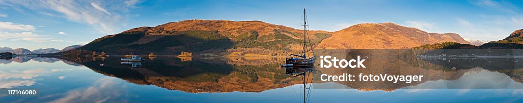 Barca a vela riflette nelle idilliache tranquillo loch Glencoe Highlands della Scozia - Foto stock royalty-free di Acqua